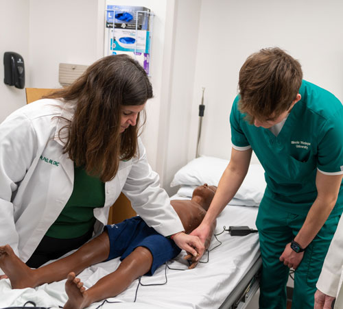 Amber and a nursing student with a patient manikin