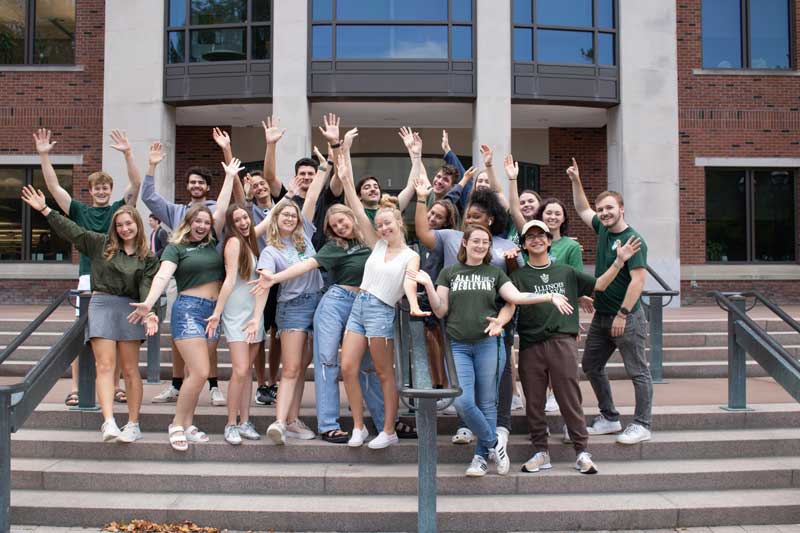 Happy students standing on the steps of Ames Library 