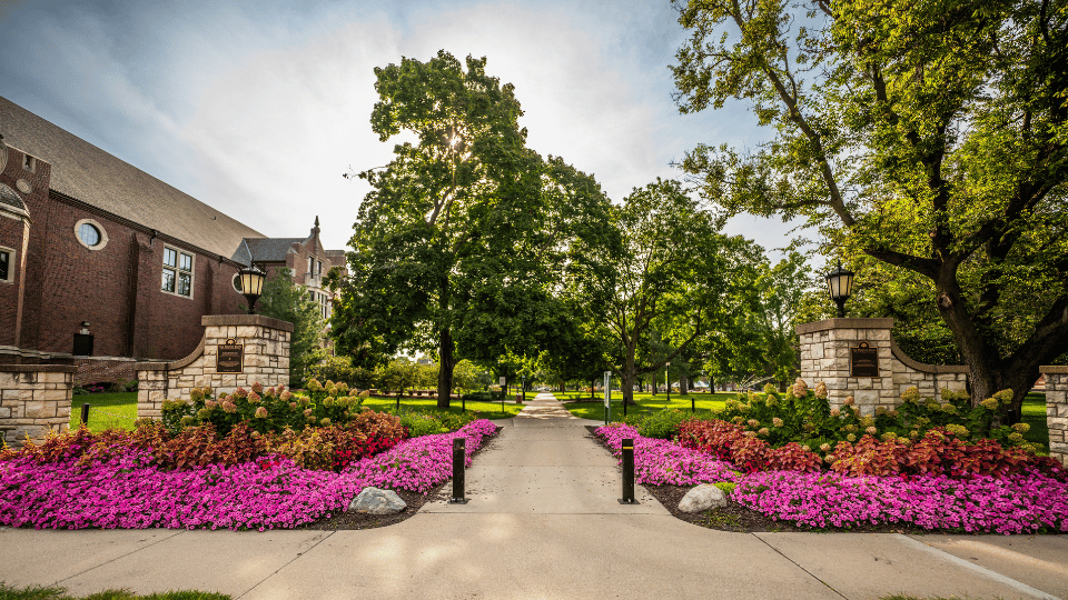 View through The Phoenix Gates to the IWU quad, lined with flowers and trees