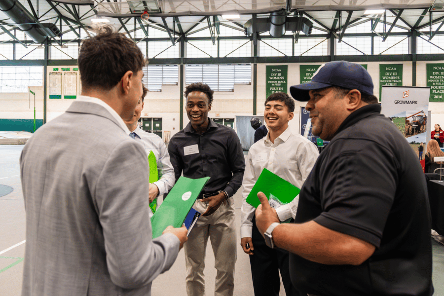 Students chat with representatives from a business at an IWU career fair