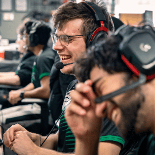 students wear headsets and laugh together in IWU esports facility